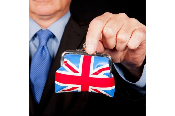 Image Man in a suit holding a coin purse decorated with the Union Jack, symbolizing UK economic and plastic tax challenges